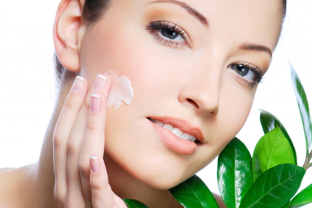 a girl lubricates her face with a rejuvenating cream