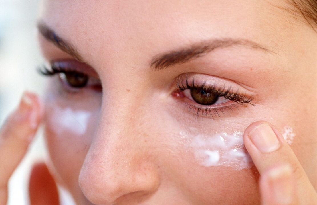 applying a cream to rejuvenate the skin around the eyes